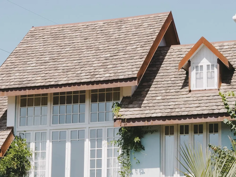 Finished home with a new shingle roof under a clear sky