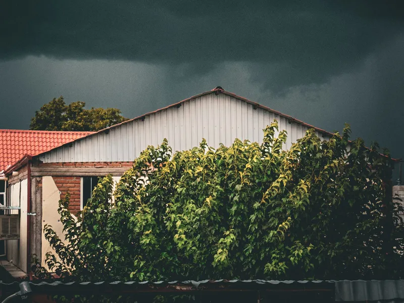 Storm clouds gathering over a residential rooftop